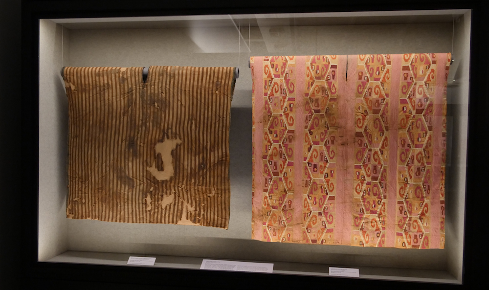A la izquierda. Túnica textil con franjas en allqa que muestran la oposición cromática. Inka-Altiplánico, norte de Chile 1400-1532 d.C. Colección Museo Chileno de Arte Precolombino, TE-302 (900 x 1000 mm). A la derecha, túnica textil con representación de lenguajes abstractos y geométricos. Wari, costa central del Perú, 700-950 d.C. Colección Museo Chileno de Arte Precolombino, 0947 (1140 x 1060 mm).