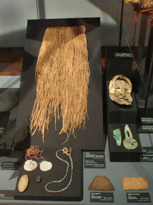 a) Faldellín de fibra vegetal. Costa de lquique – Pescadores Temp ranos {Chinchorro). Colección Museo Regional de lquique. b) Colgante de conchas de ostión y collar de cuentas de concha. Costa de lquique – Pescadores Tempranos. Colección Museo Regional de lquique. c) Tablilla porta plumas y colgante. Madera.Costa de Taltal – Pescadores Tardíos (1000 – 1470 d.C.). Colección Museo Augusto Capdeville y Univesidad de Antofagasta . d) Pendiente y cuchara-espátula .Cobre.Costa de Taltal – Pescadores Tardíos (1000 – 1470 d.C.). Colección Museo Augusto Capdeville.