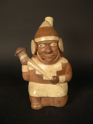 Botella asa-estribo: Guerrero arrodillado portando porra y escudo,con tocado,orejeras vestido con túnica y faldellín.Museo Larco, Lima – Perú I ML001571