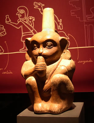 Botella asa-estribo : Mono comiendo,con orejeras , túnica y bolsa colgando al Cuello. Museo Larco, Lima – Perú / ML008202