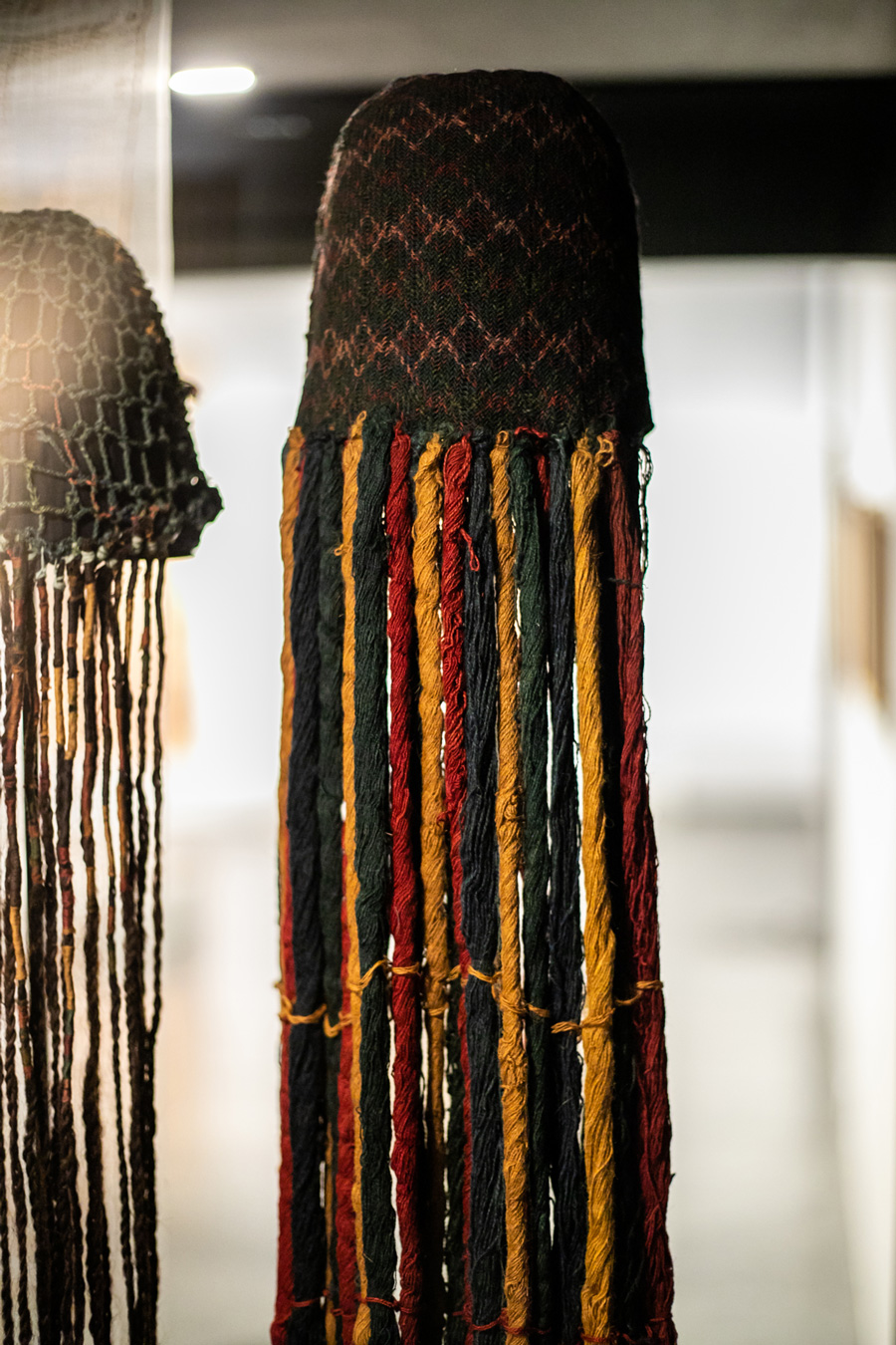 Gorro con flecaduras. Fringed hat. Tejido entrelazado oblicuo (sprang), torsión (flecos). Fibra de camélido. Oblique interlacing weave (sprang), torsión (fringes). Camelid fiber. Cultura Nasca, costa sur de Perú, 100-700 DC. Museo Chileno de Arte Precolombino-Colección Apelles, PE-232. (920 x 160 mm).