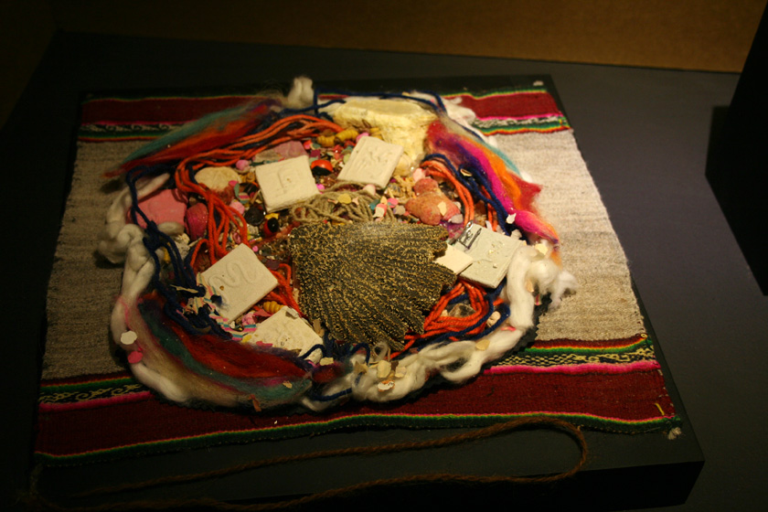 “Mesa ritual” con ofrendas sobre mantel-altar (inkuña). Fibra de camélido, azúcar, papel, incienso, metal, grasa de animal. Cultura Aymara, Bolivia. 32 cm (diám.), MCHAP MO-6.